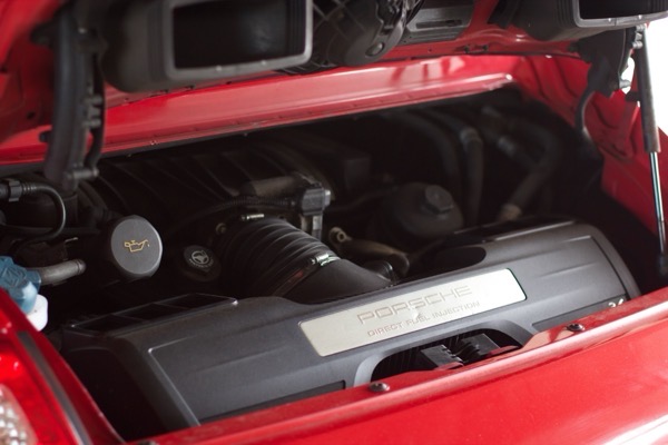 Engine bay showing Porsche Direct Fuel Injection cover