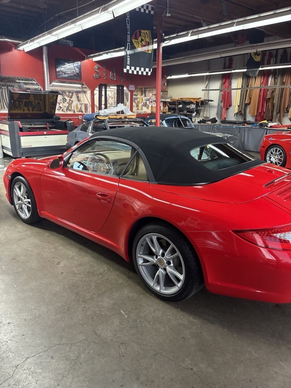 Car with soft top up at upholstery shop